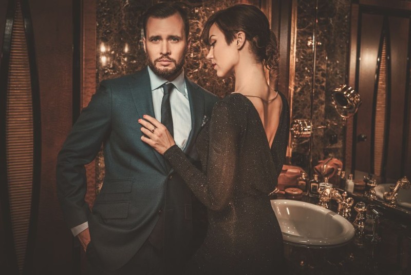 Well-dressed man and woman standing side by side, symbolizing confidence, self-image, and why resolutions fail when people focus only on losing weight instead of pursuing the deeper transformation and lifestyle changes connected to their ultimate goals.